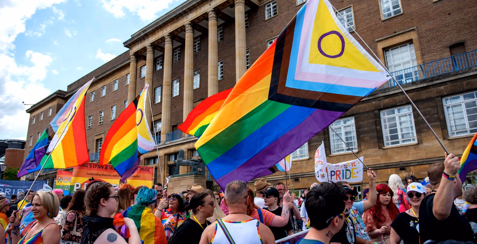 Crowd of people waving pride flags in Norwich