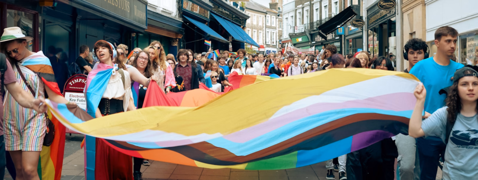 Group of people carrying a big Norwich Pride flag